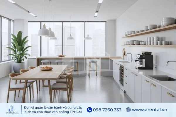 Mẫu thiết kế pantry văn phòng hiện đại, bàn ăn gỗ dài, kệ bếp trắng và cây xanh trang trí gần cửa sổ.